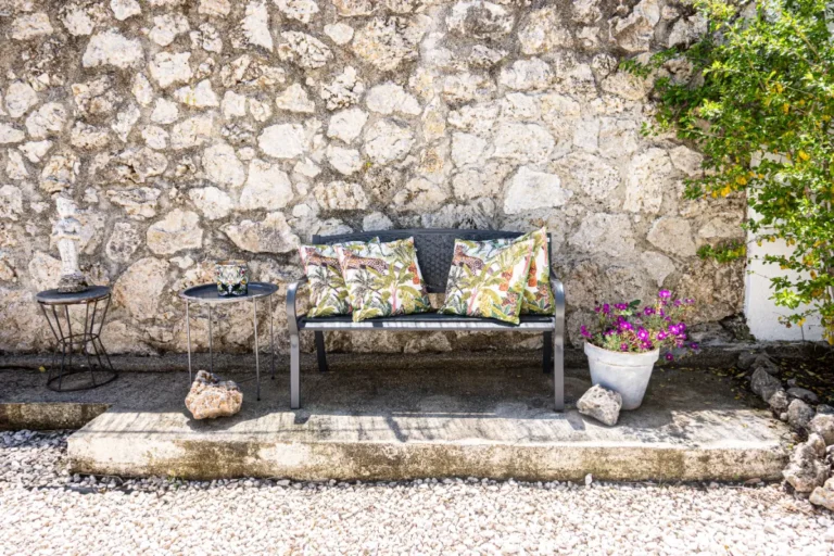 Bench with cushions in front of a stone wall