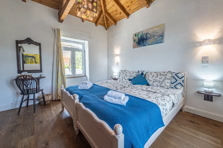 Shiva room in the main house with large bed and wooden ceiling