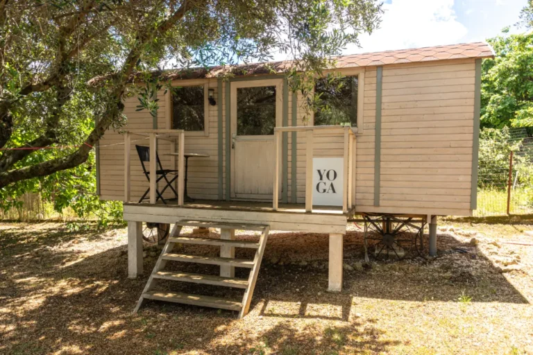 Yoga tiny house at Manto Corfu, a wooden cabin with a small deck under the trees