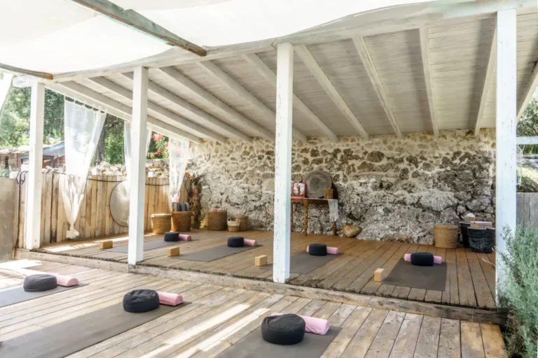 Yoga shala with mats and bolsters under a white roof