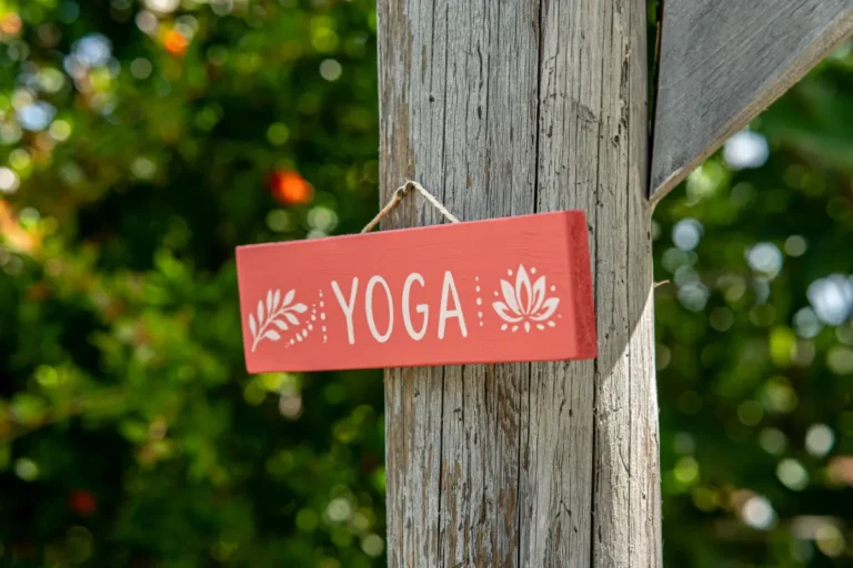 Hand-painted yoga sign on a wooden post