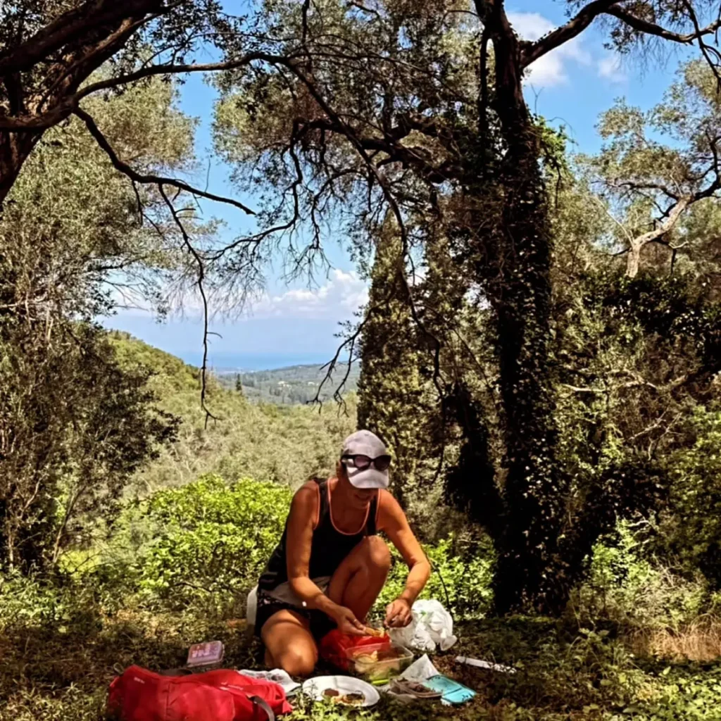 Picnic break in the shade of old trees with a view over the hills to the sea